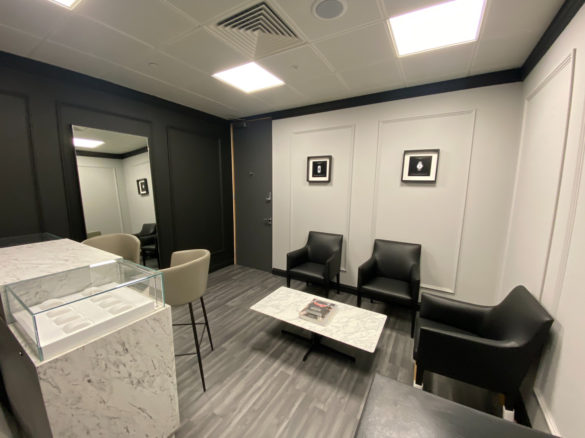 Premier Watch Co interior in Canary Wharf, with marble display counters and black leather seating